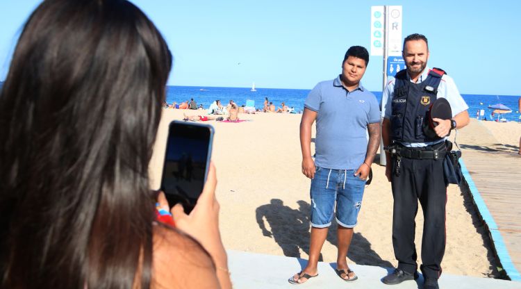 La parella de Bryan Gabino fent-li una foto amb l'agent dels Mossos que li va salvar la vida a Platja d'Aro. ACN