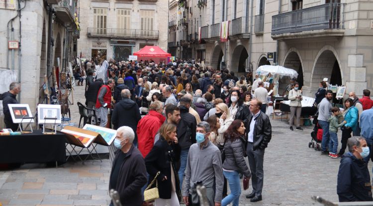 Diverses persones passejant per la plaça del Vi durant la fira de la pintura. ACN