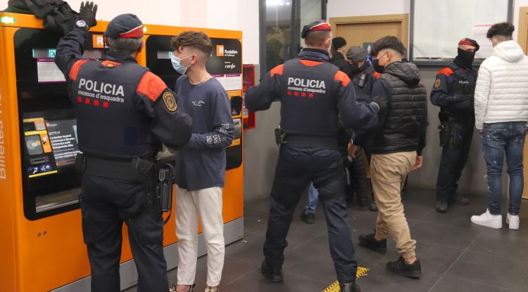 Diversos agents dels Mossos d'Esquadra escorcollant a joves en un operatiu policial a l'estació del tren de Blanes. ACN