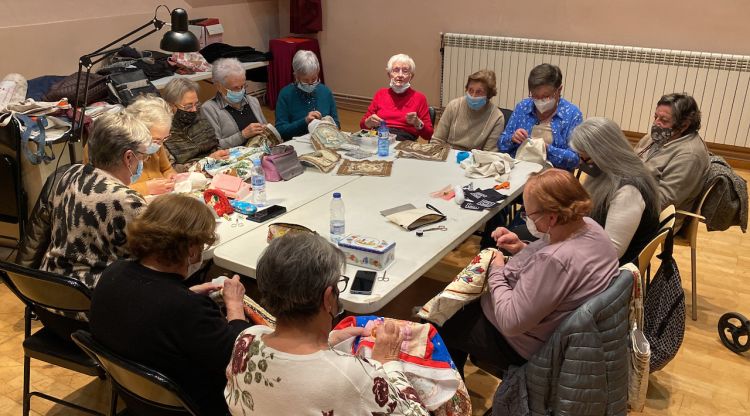 Un grup de dones usuàries del Casal d'Avis de Puigcerdà fent labors en una sala del Museu Cerdà. ACN