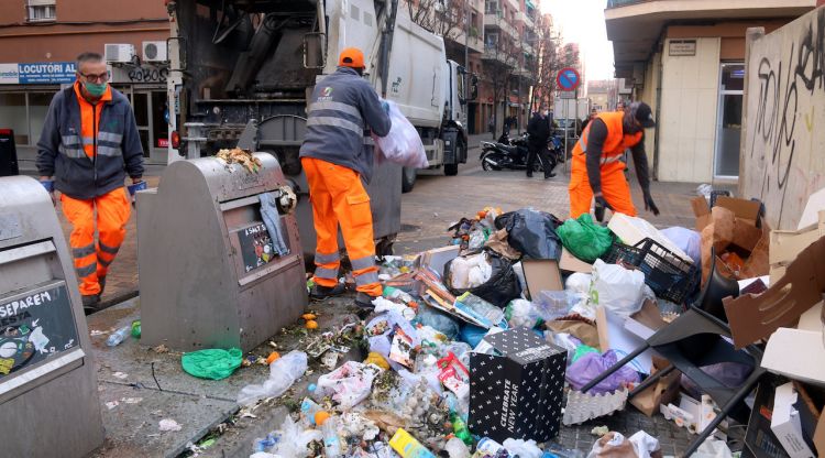 Treballadors recollint deixalles i andròmies acumulades al carrer Torras i Bages de Salt el cinquè dia de vaga. ACN