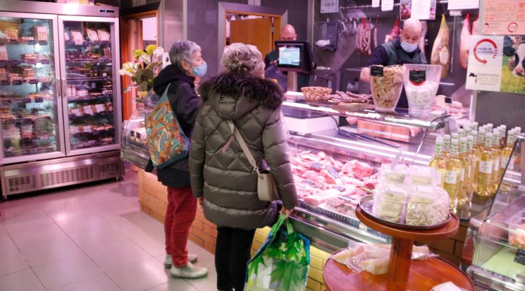 Dues clientes esperen al mostrador d'una carnisseria de Cruïlles. ACN