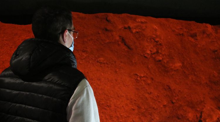 Un joves observant part del volcà Puig del Roser a l'interior de l'Espai Cràter. ACN