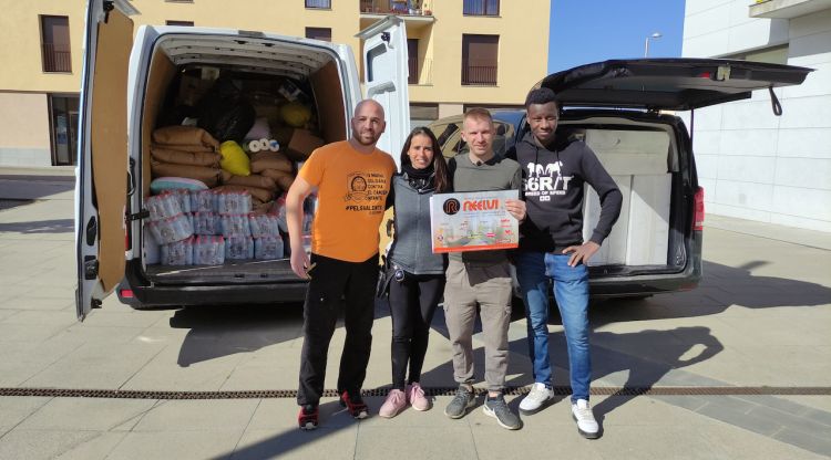 Els tres joves que marxen cap a la frontera amb les furgonetes plenes i una companya que els ha ajudat en la logística. ACN