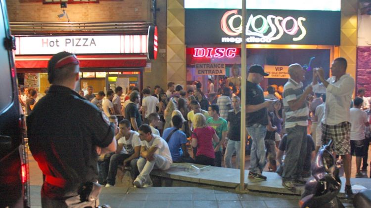 Un agent vigila els turistes davant la discoteca Colossos © AG