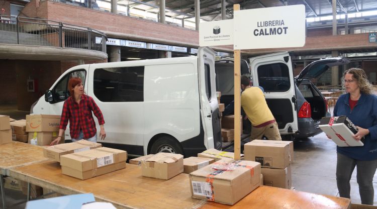Diversos treballadors de la llibreria Calmot descarregant llibres d'una furgoneta a Fira de Girona. ACN