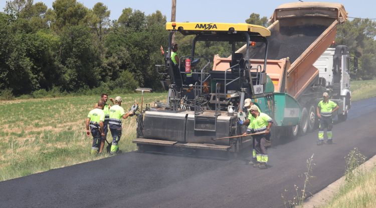 Una màquina reasfalta la carretera GIV-5132 amb un asfalt fet amb ampolles reciclades. ACN