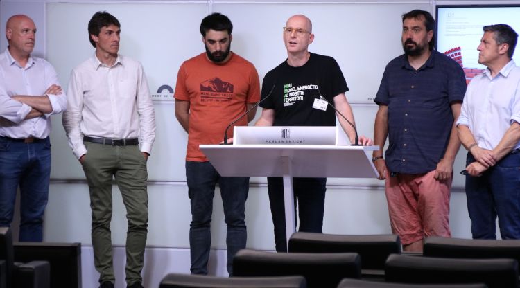 El portaveu de la plataforma No a la MAT, Xavier Amat, acompanyat de diputats d'ERC, JxCat, CUP i ECP en una roda de premsa al Parlament. ACN