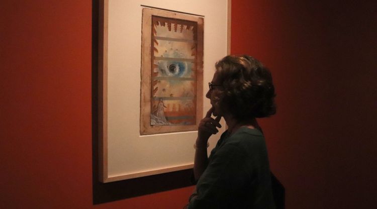 Una dona mira una de les obres que forma part de l'exposició temporal del Castell Gala Dalí de Púbol. ACN