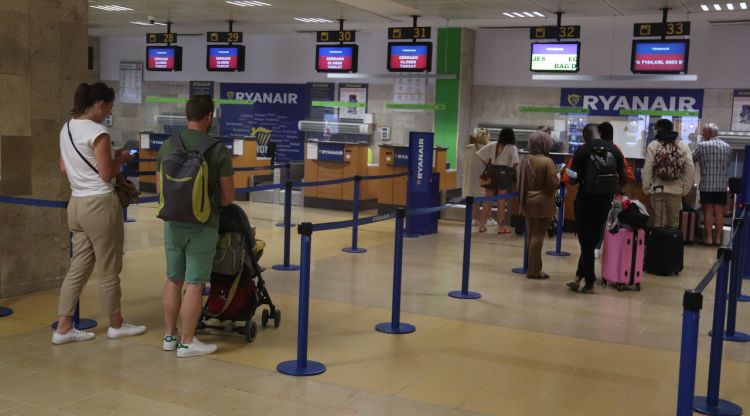 Els taulells de passatgers de Ryanair a l'aeroport de Girona amb alguns passatgers esperant per facturar. ACN