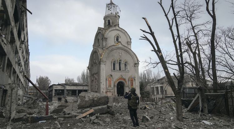 Un militar ucraïnès fa una foto d'una església després del bombardeig en una zona residencial de Mariúpol. Evgeniy Maloletka / Associated Press