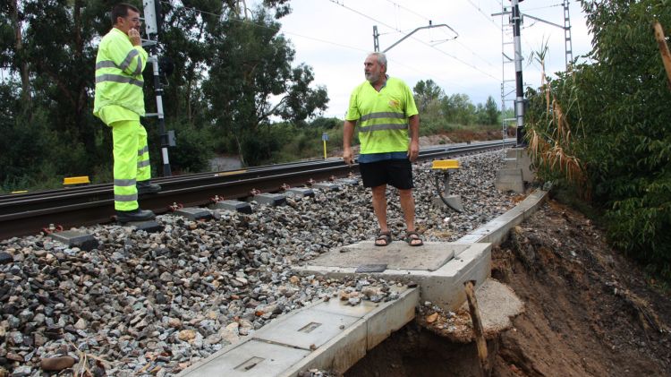 Els operaris inspeccionen el punt de la via a Flaçà on la pluja ha descalçat el talús © ACN