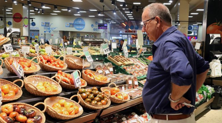 Un home compara els preus de la verdura en un supermercat de Barcelona. ACN
