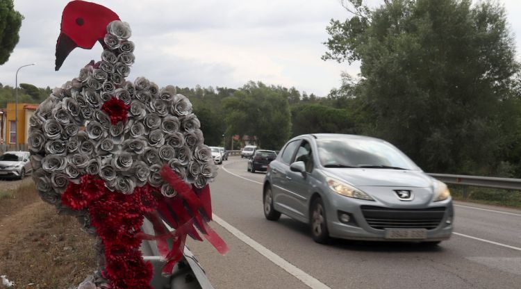 Diversos rams que recorden algunes de les víctimes mortals a la C-63 mentre de fons, desenfocats, circulen diversos vehicles. ACN