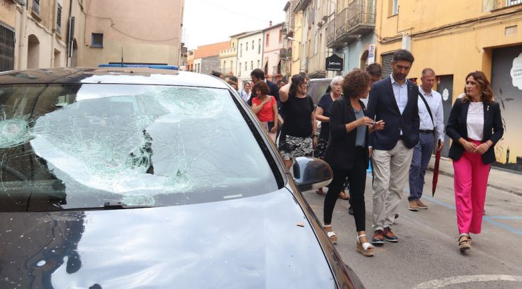El vicepresident del Govern, Jordi Puigneró, i la consellera de Presidència, Laura Vilagrà, passen per davant d'un cotxe amb els vidres trencats per la pedregada. ACN