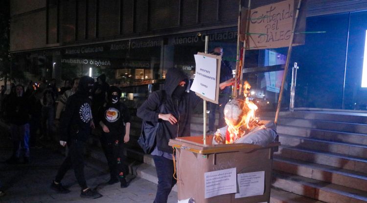 Els manifestants cremant el contenidor pel diàleg amb un ninot que representava el president Aragonès. ACN