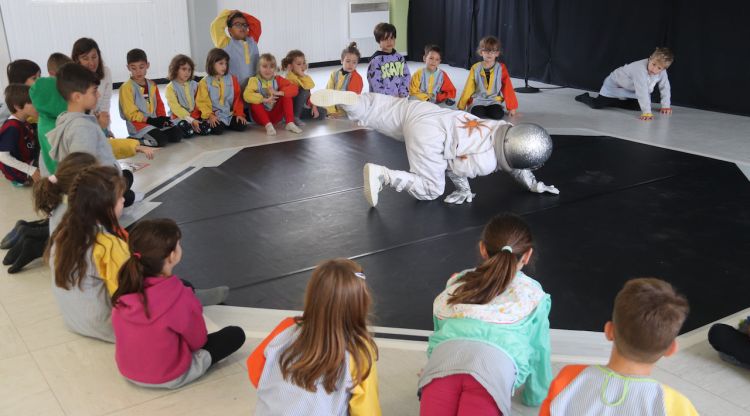 Una ballarina interpreta una astronauta davant d'alumnes de 1r de l'escola Bosc de la Pabordia de Girona. ACN