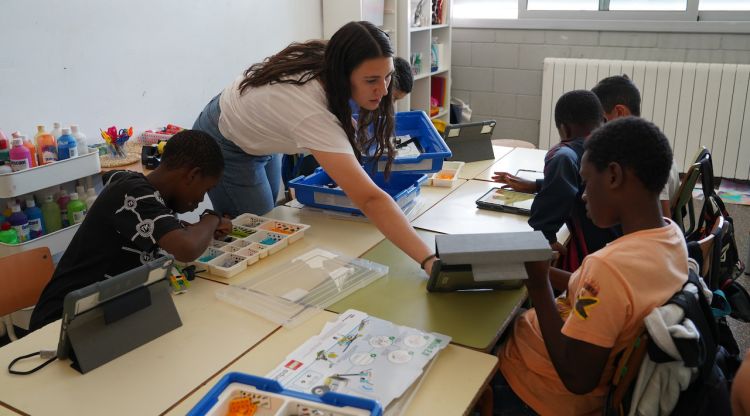 Una professora comprova l'activitat d'un alumne que està fent un taller de Lego dins del projecte Talent Maker