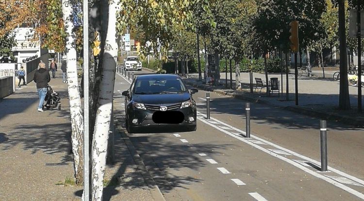 Un vehicle estacionat al damunt del carril bici després de passar entre les pilones d'acer. Caseagustí