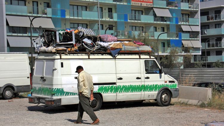 Un drapaire passa pel costat d'una furgoneta carregada de material per vendre al Marroc © ACN