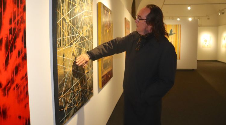 L'artista Pep Camps acariciant una de les seves obres exposades a la Casa de Cultura de Girona. ACN