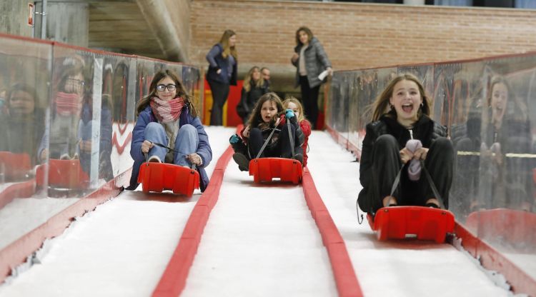 Nenes baixant pel tobogan de la pista de gel de Girona. ACN