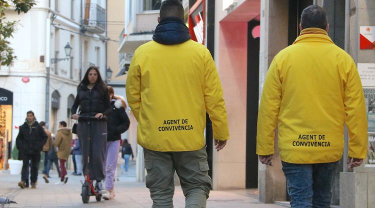 Dos agents de convivència amb una noia amb patinet al fons. ACN