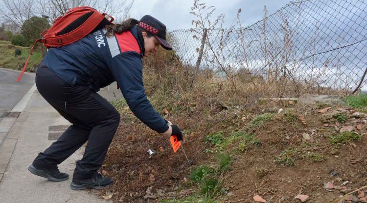 L'agent cívica posant una banderola al costat d'una tifa abandonada