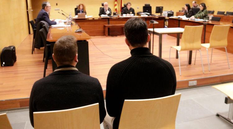 D'esquenes, els acusats d'abusar sexualment en grup d'una menor de 15 anys. Foto del judici a l'Audiència de Girona. ACN