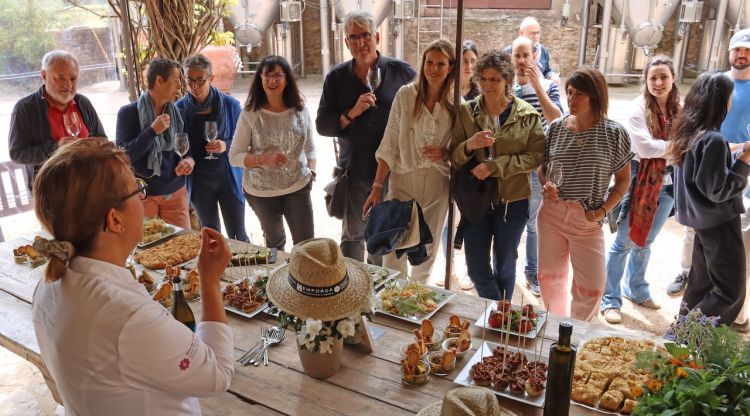 Iolanda Bustos davant les seves creacions culinàries amb flors i els assistents a l'activitat. M. Estarriola