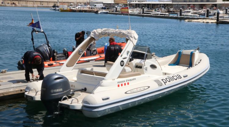 Dos mossos preparant l'embarcació per sortir del moll pesquer de l'Escala. ACN