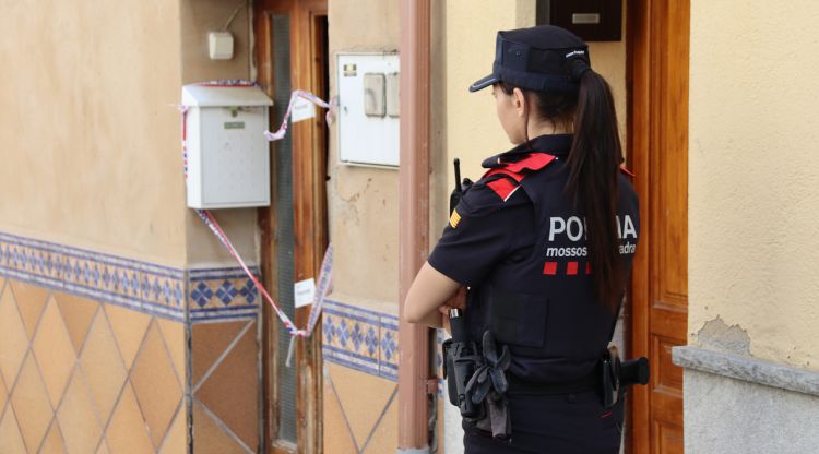 Una agent dels Mossos davant de la casa del presumpte assassí, que es troba precintada. ACN