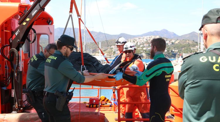 Efectius de la Guàrdia Civil, dels GEAS i de Salvament Marítim baixant el submarinista mort de l'embarcació. ACN