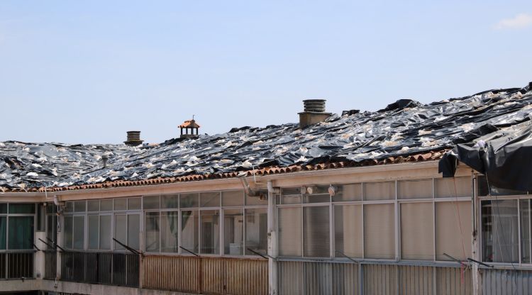 Part del bloc afectat amb els plàstics cobrint la teulada. ACN