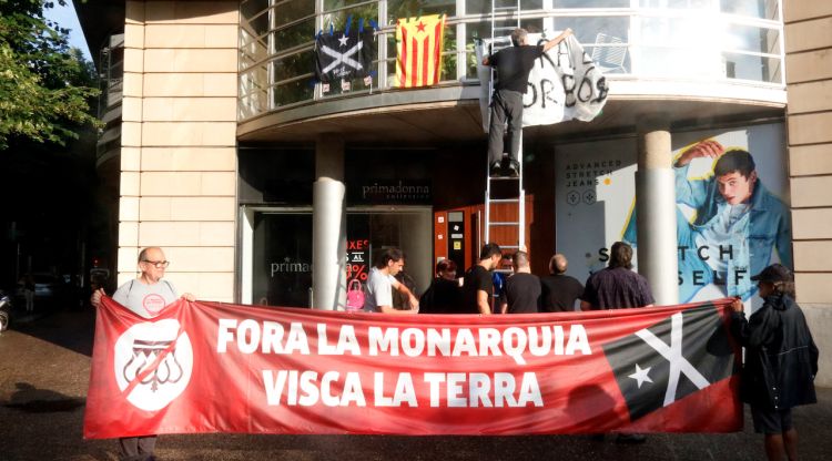 Els membres de la coordinadora antimonàrquica penjant la pancarta contra els borbons a la façana de la FPdGi. ACN