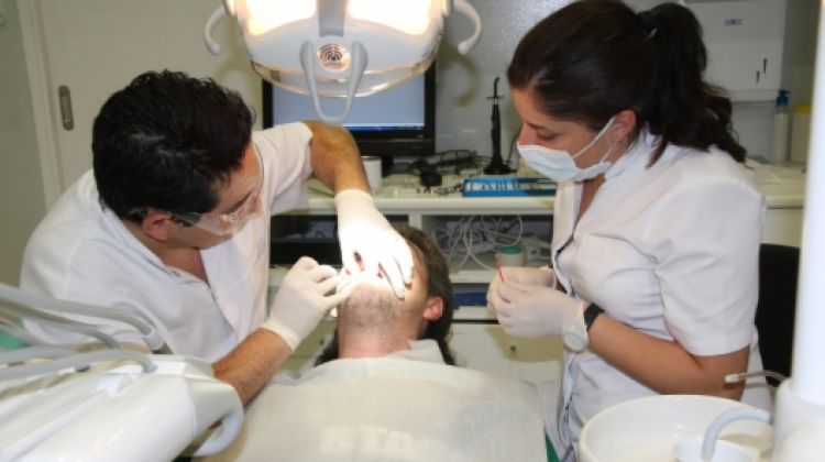 Un dels dentistes que col·laboren desinteressadament a la clínica atenent a un pacient (arxiu) © ACN