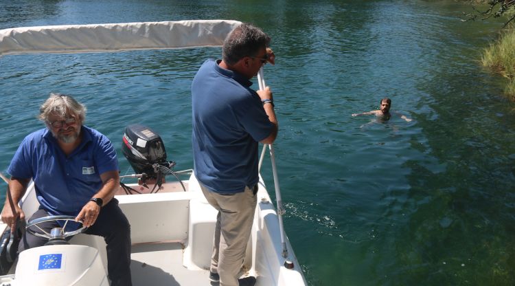 La barca del Consorci de l'Estany amb un banyista que s'ha llançat a l'aigua en una zona prohibida. ACN