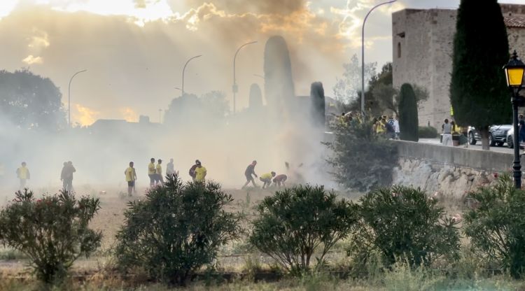 Els participants a la cercavila, intentant apagar les flames. Ràdio Capital