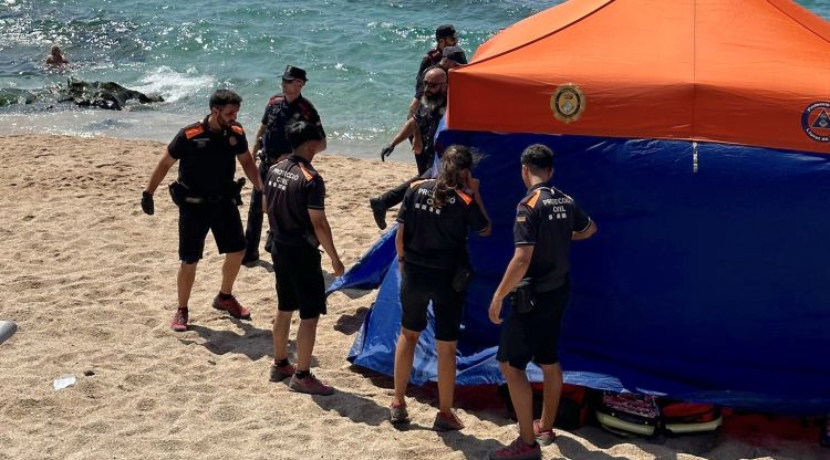 Membres de Protecció Civil assistint a una víctima d'ofegament a la platja (arxiu)