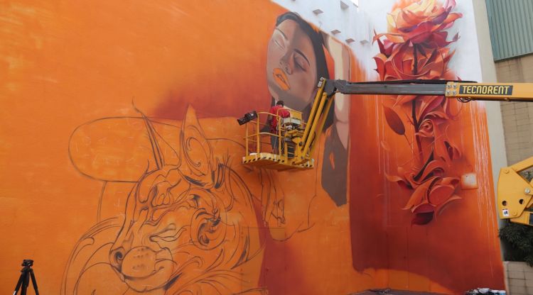 Un artista pinta un mural de grans dimensions al costat de la plaça de Catalunya. ACN