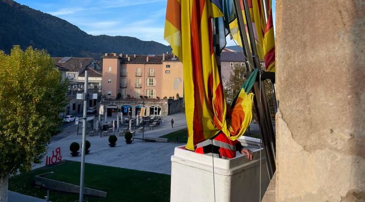 Un operari retirant l'estalada del balcó de l'Ajuntament de Ripoll