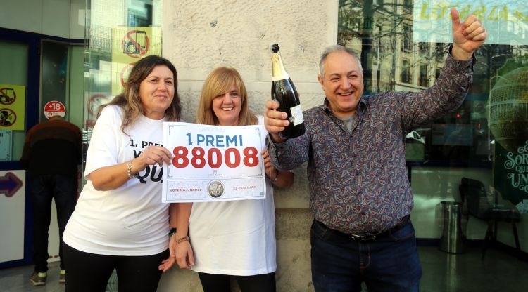 El propietari de l'administració Sagarrull de Girona amb una ampolla de cava per celebrar que ha repartit la grossa. ACN