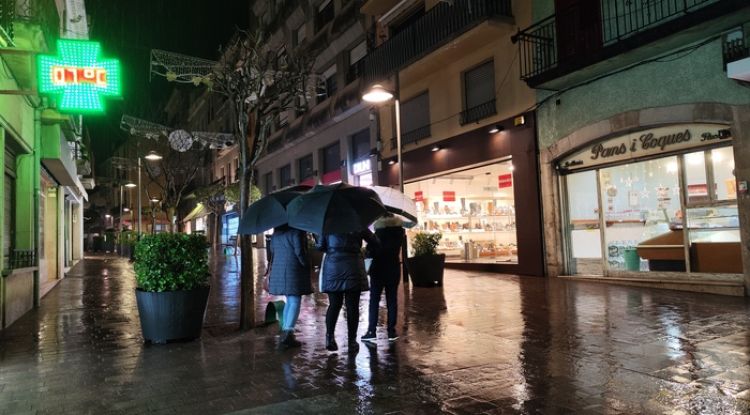 Uns veïns de Palafrugell, ahir a la tarda amb els paraigües oberts. Margarida Bonet Alsina