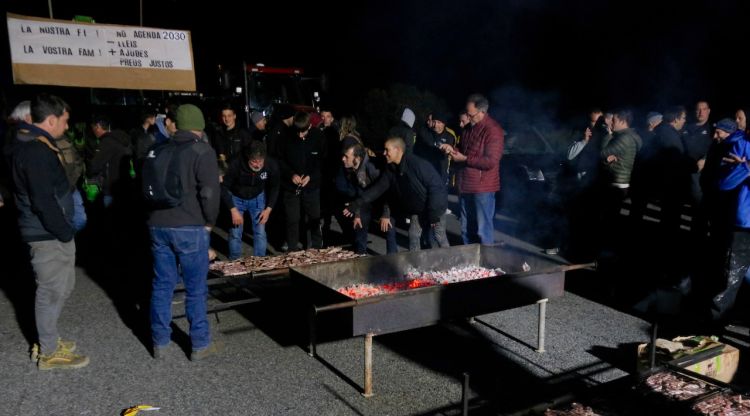 Els pagesos aquesta passada nit, preparant el sopar a peu d'autopista. ACN