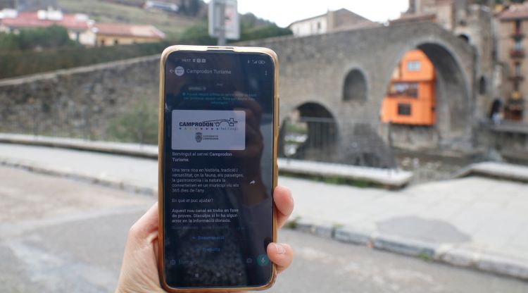 Un mòbil amb la guia turística i el pont romànic de Camprodon. ACN