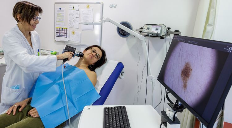 La doctora analitza les pigues a una pacient amb el dermatoscop