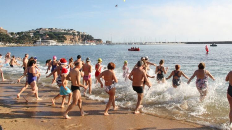 Els banyistes corren a l'aigua després de sentir el tret de sortida © ACN