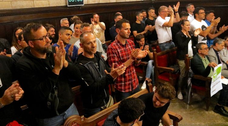 Els agents de la Policia Municipal aplaudint al ple després que s'hagi aprovat l'acord que posa fi al conflicte de les hores extra. ACN