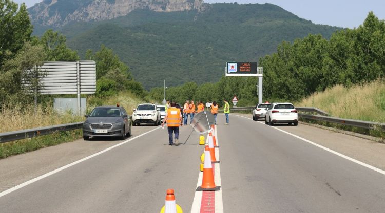 Tècnics inspeccionant la deformació a l'asfalt a la C-37 per sol·lucionar el problema i poder reobrir la via. ACN