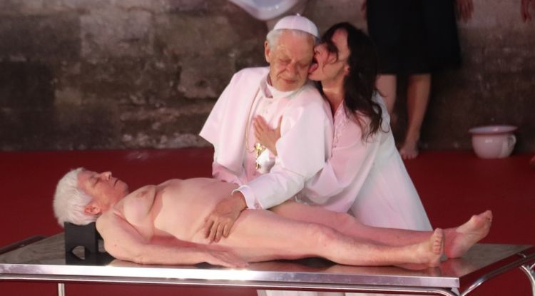 Angélica Liddell llepa l'orella d'un actor que interpreta Ingmar Bergman disfressat de Papa a l'espectacle 'DÄMON'. ACN